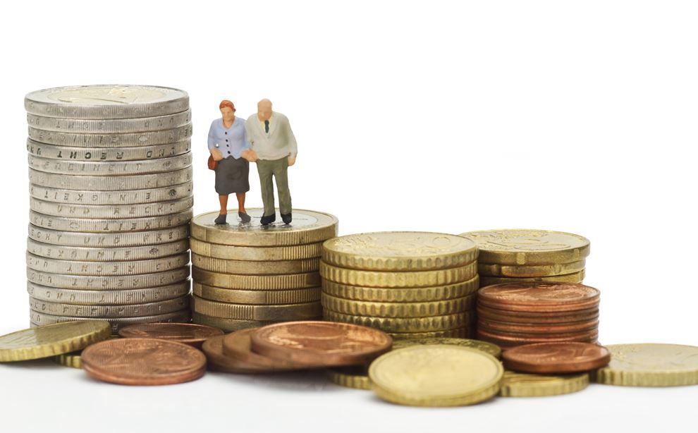 figur at et ældre ægtepar, placeret ovenpå en bunke mønter